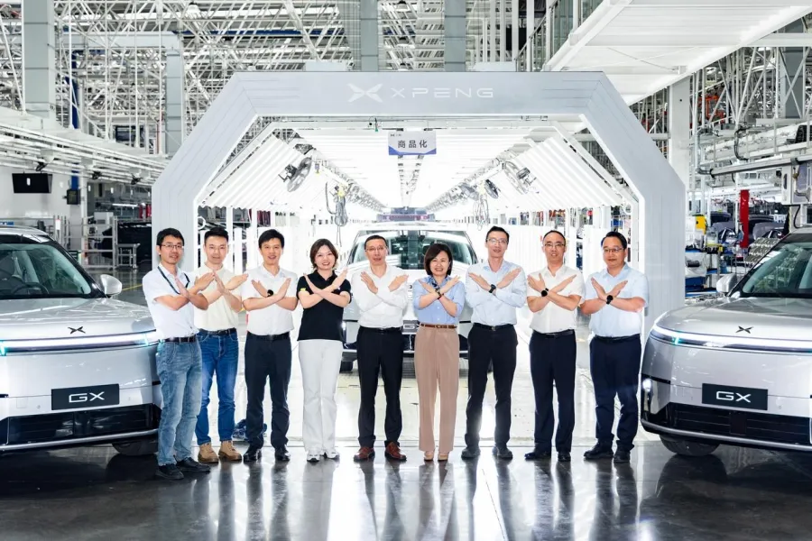 Two XPeng GX vehicles at either side of a production line archway in the Guangzhou plant