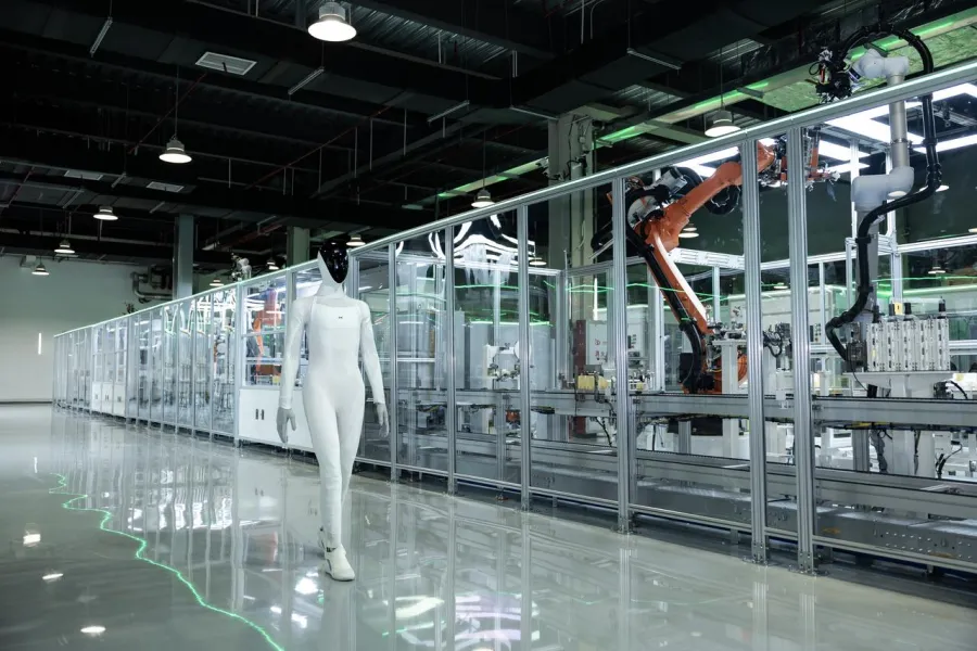 The IRON humanoid robot walking beside XPeng's newly commissioned robot production line in Guangzhou